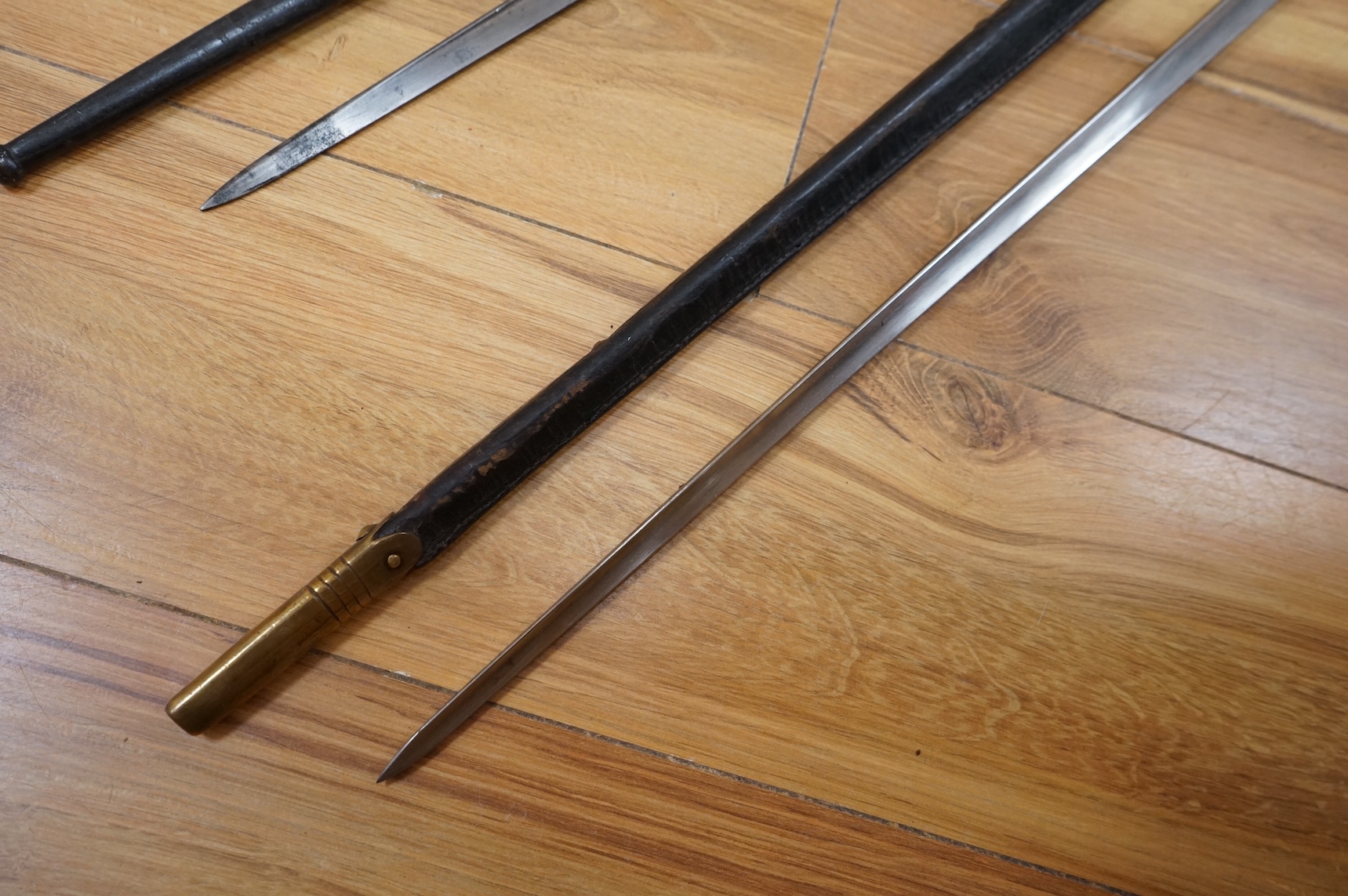 Three bayonets; a gras bayonet, a Lebel bayonet and an Indian Enfield style triangular socket bayonet, all in the original scabbards